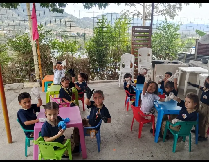 Estudiantes del preescolar con guantes en el patio del colegio, frente al paisaje de La Plata