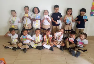 Niños y niñas del colegio muestran sus proyectos de arte frente a la cámara